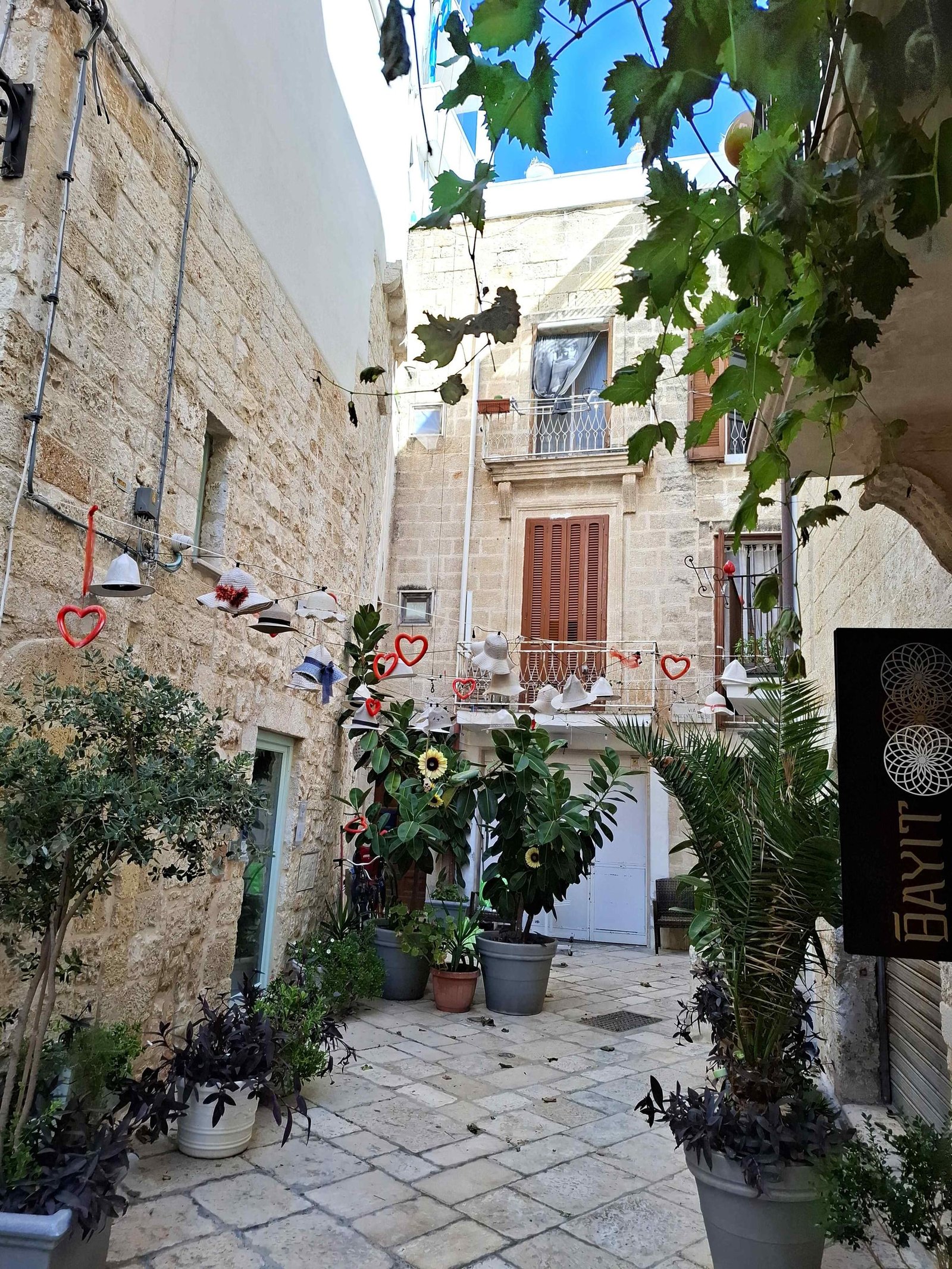 Străduță îngustă cu case albe din calcar în centrul istoric Polignano
