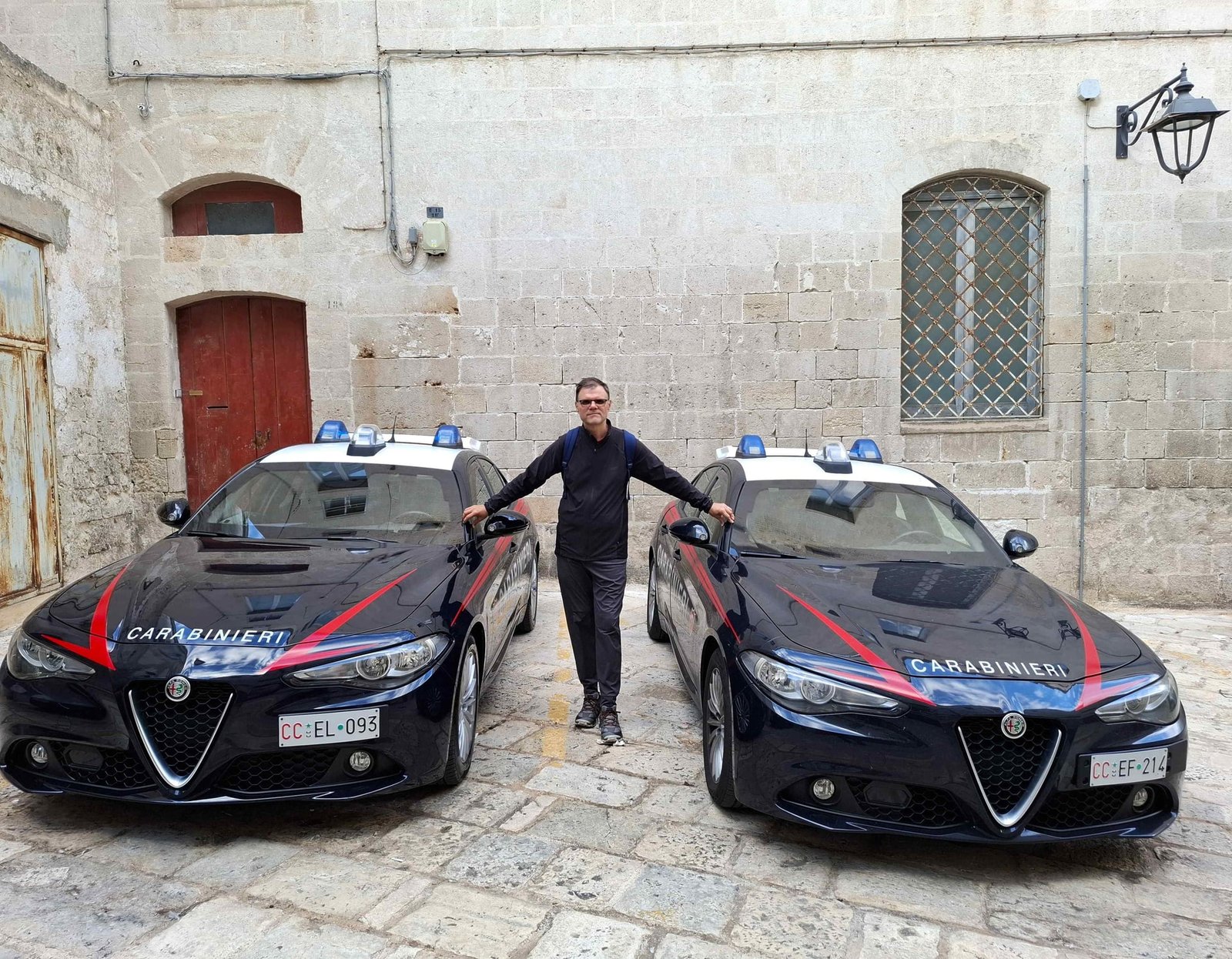 Autorul blogului Călător Povestitor lângă două mașini Lancia ale poliției italiene în Monopoli